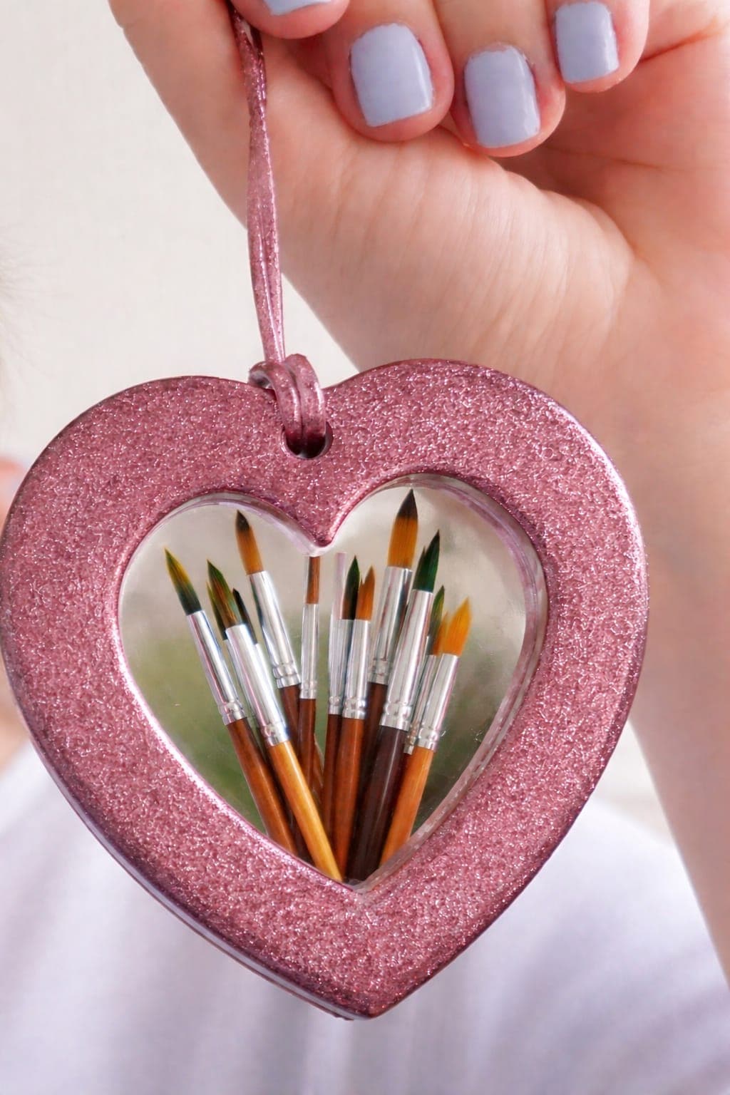 Pinceles de acuarela dentro de un corazón rosa — materiales del taller